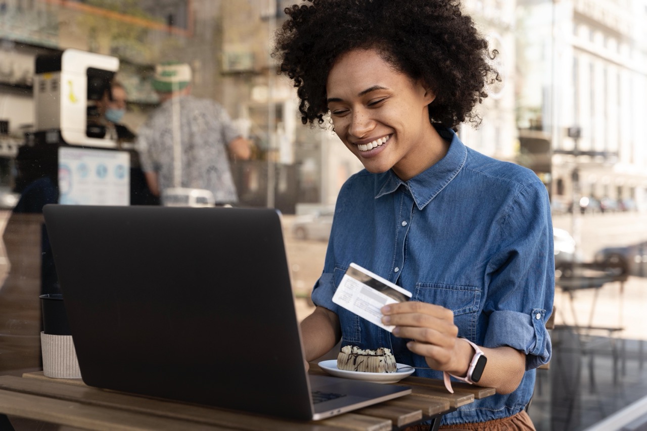 mulher pagando uma assinatura no notebook com cartão de credito, uma receita recorrente em customer success